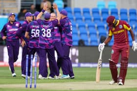 Scotlands Michael Leask (C) celebrates with teammates after dismissing West Indies captain Nicholas Pooran