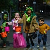 Children pose for a picture as they go trick-or-treating for Halloween in east London. 