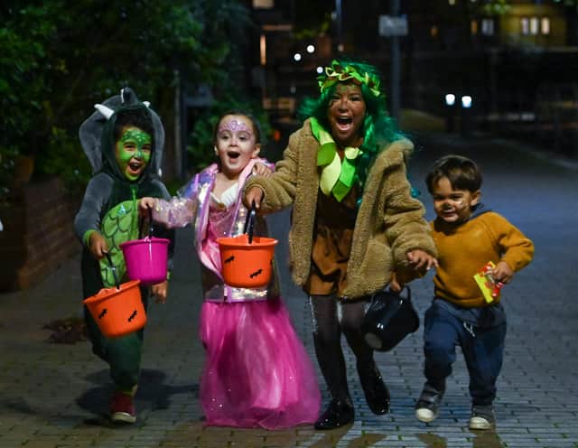 Children pose for a picture as they go trick-or-treating for Halloween in east London. 
