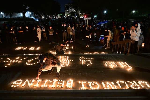 Candles are lit as people protest the deaths caused by an apartment complex fire in Urumqi, Xinjiang, China