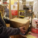 Customers weigh packages at the post office.