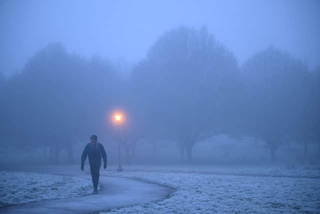 A walker makes their way through fog on a frosty morning at Primrose Hill in north London. (Photo by Justin TALLIS / AFP) (Photo by JUSTIN TALLIS/AFP via Getty Images)