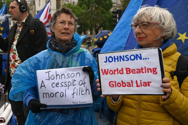 Demonstrators protest against Britain’s Prime Minister Boris Johnson, as he makes a statement in the House of Commons in London, on May 25, 2022 following the publication of the Sue Gray report
