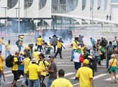 Supporters of Brazilian former President Jair Bolsonaro clash with the police during a demonstration outside the Planalto Palace in Brasilia on January 8, 2023. - Brazilian police used tear gas Sunday to repel hundreds of supporters of far-right ex-president Jair Bolsonaro after they stormed onto Congress grounds one week after President Luis Inacio Lula da Silva's inauguration, an AFP photographer witnessed. (Photo by EVARISTO SA / AFP) (Photo by EVARISTO SA/AFP via Getty Images)