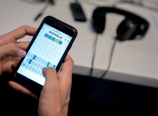 This photo illustration shows a person playing online word game “Wordle” on a mobile phone in Washington, DC on January 11, 2022 (Photo by STEFANI REYNOLDS/AFP via Getty Images)