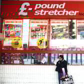 A woman waits outside a branch of Poundstretcher near Lewisham high street.