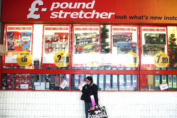 A woman waits outside a branch of Poundstretcher near Lewisham high street.