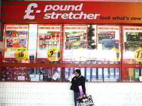 A woman waits outside a branch of Poundstretcher near Lewisham high street.