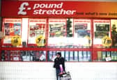 A woman waits outside a branch of Poundstretcher near Lewisham high street.