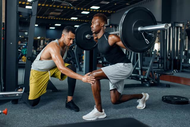 Man with his trainer in gym (Adobe)