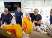 Volunteers sort food into food parcels at a community charity.  