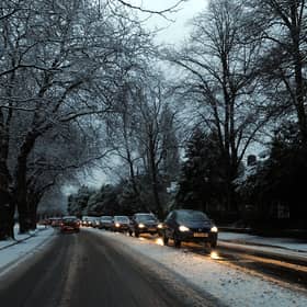 Cars drive on snowy roads in Liverpool.