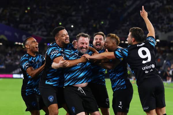 Lee Mack celebrates his goal with World XI teammates including Steven Bartlett (left-centre)