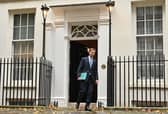 Britain's Chancellor of the Exchequer Jeremy Hunt walks out of Number 11 Downing Street 