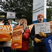 Demonstrators hold placards as they take part in a protest by junior doctors, amid a dispute with the government over pay, outside of Saint Mary's Hospital, in Manchester, on March 15, 2023. 