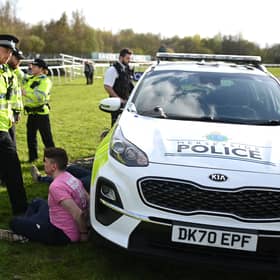An animal rights protester is apprehended by police officers ahead of the Grand National. 