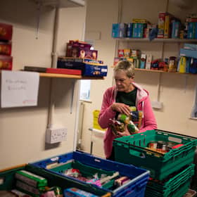 A worker at the Coventry Foodbank centre in Queens Road Baptist Church collates donated food items into parcels that will be provided to people arriving with a foodbank voucher.