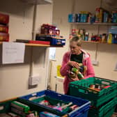 A worker at the Coventry Foodbank centre in Queens Road Baptist Church collates donated food items into parcels that will be provided to people arriving with a foodbank voucher.