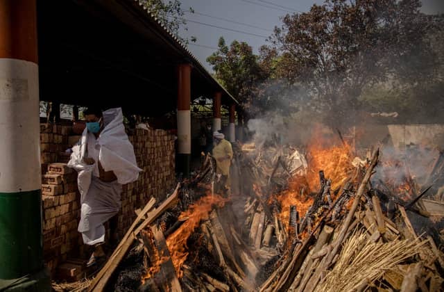 A priest avoids funeral pyres in India, which has been badly hit by a surge in coronavirus cases. (Photo by Anindito Mukherjee/Getty Images)