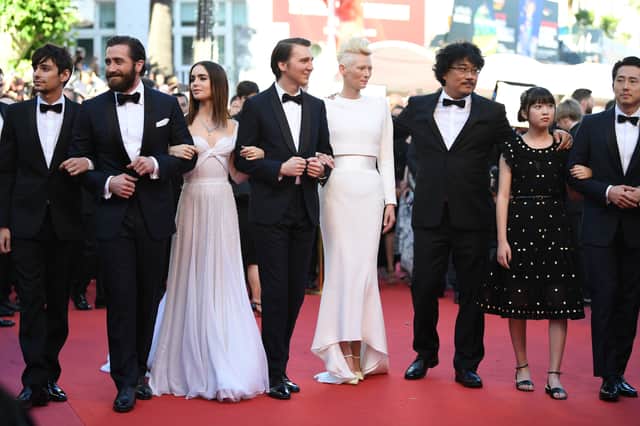 Actors Devon Bostick, Jake Gyllenhaal, Lily Collins, Paul Dano, Tilda Swinton, director Bong Joon-Ho, actors Ahn Seo-Hyun and Steven Yeun attend the "Okja" screening during the 70th annual Cannes Film Festival. Image: Pascal Le Segretain/Getty Images)