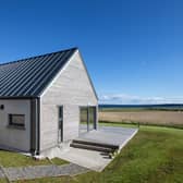 The longhouse is positioned low on a hillside, just above a sandy beach on the coast of the stunning island of Lewis.