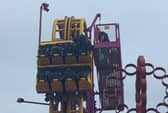 Horrified onlookers watched as rescuers scrambled to the aid of eight terrified people stuck “at the top” of a 22-metre rollercoaster.