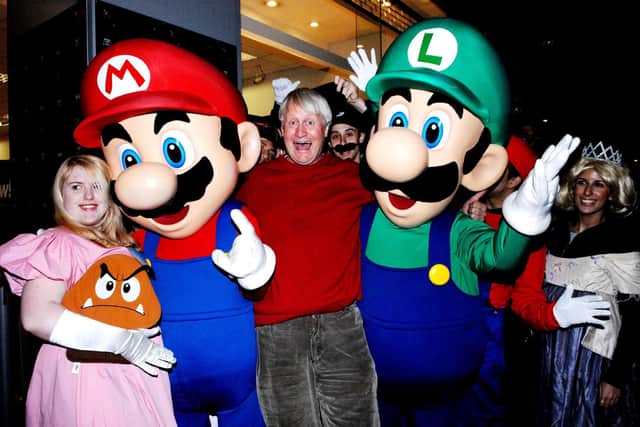 The voice of Super Mario, Charles Martinet (centre), poses with fans outside GAME Oxford Street, central London, on the evening that Super Mario Galaxy on the Nintendo Wii goes on sale in the UK.