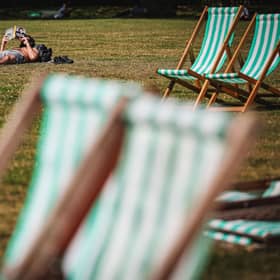 A man reads a book while sunbathing in Green Park in central London on September 5, 2023 as the country experiences a late heatwave. 