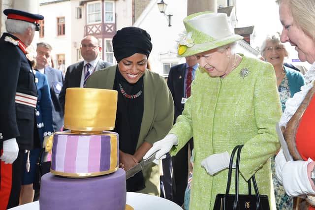 Queen Elizabeth II receives a birthday cake from Nadiya Hussain, winner of the Great British Bake Off, during her 90th Birthday Walkabout on April 21, 2016. Image: John Stillwell - WPA Pool/Getty Images