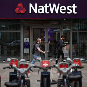 Pedestrians walk past a branch of a NatWest bank in London.