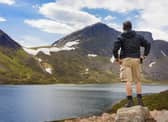 A man looking over a loch to a peak in the Cairngorm Mountains in the Scottish Highlands. (George Clerk via Getty Images Signature)