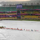 Members of the ground staff cover the field as rain delays the warm-up match between Bangladesh and England ahead of the ICC men's cricket World Cup, at the Assam Cricket Association Stadium in Guwahati on October 2, 2023. (Photo by Biju BORO / AFP) (Photo by BIJU BORO/AFP via Getty Images)
