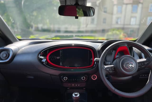 Red accents and partial leather characterise the dashboard and interior of the Aygo X Undercover. Credit Steven Chisholm
