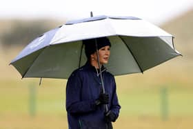 Actress Catherine Zeta-Jones shelters under an umbrella during the first round of the Dunhill Championship.