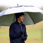 Actress Catherine Zeta-Jones shelters under an umbrella during the first round of the Dunhill Championship.
