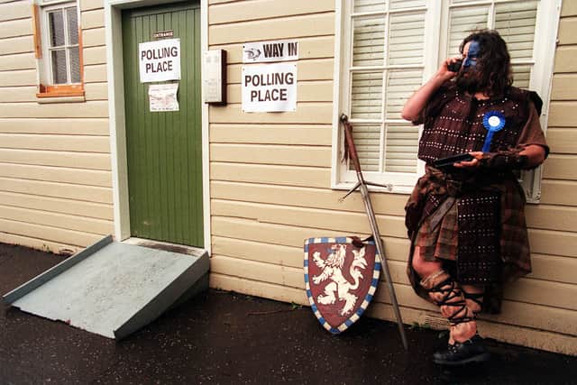 William Wallace (right), standing as an Independent Braveheart candidate for Edinburgh Central, after leaving the polling station to cast his vote in the elections for the Scottish parliament, with his broadsword and full Highland dress. (1999)