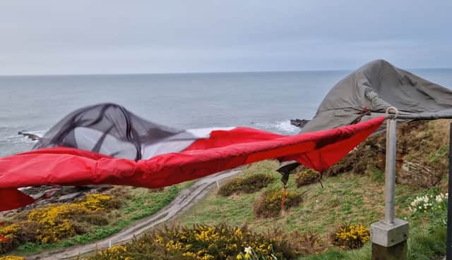 Tent drying in the wind on a rail next to a golf course