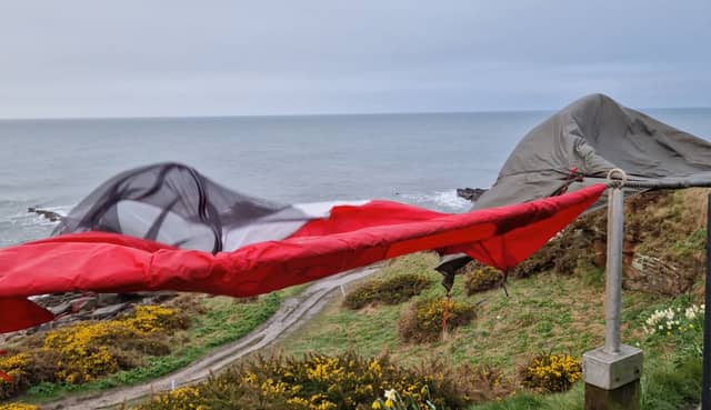 Tent drying in the wind on a rail next to a golf course
