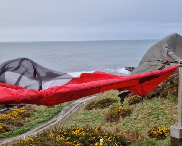 Tent drying in the wind on a rail next to a golf course 