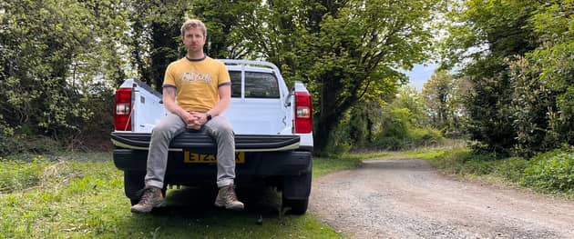 Scotsman writer Steven Chisholm sits in the back of the Ford Ranger XL test car near a section of gravel track. Credit: Steven Chisholm