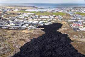 Cooled lava reaches the outskirts of a on evacuated fishing town on May 23, 2024, at Grindavik, Iceland. There have been a series of eruptions in the country's Reykjanes Peninsula since last autumn, causing extensive damage and the evacuation of the town of Grindavik. (Photo by John Moore/Getty Images)
