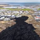 Cooled lava reaches the outskirts of a on evacuated fishing town on May 23, 2024, at Grindavik, Iceland. There have been a series of eruptions in the country's Reykjanes Peninsula since last autumn, causing extensive damage and the evacuation of the town of Grindavik. (Photo by John Moore/Getty Images)