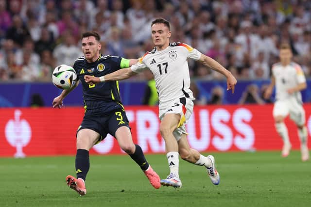 Andy Robertson of Scotland and Florian Wirtz of Germany compete for the ball.