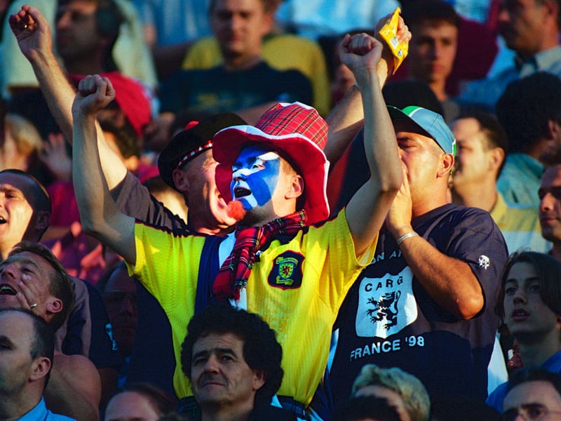 A Scotland fan with his face painted cheers the team on against Morocco.