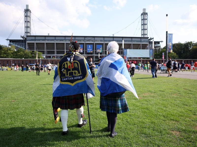Two Scotland fans, draped in the saltire, head to the Cologne Arena ahead of the game with Switzerland.