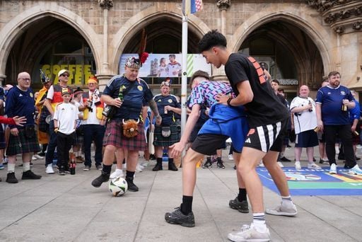 Scotland fans play football at Marienplatz square.