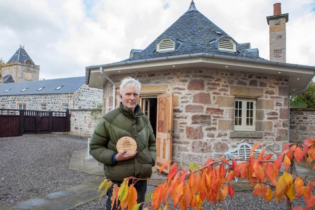 Joe with his award. The clocktower and steadings are the current renovation project