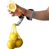 A Third Thumb being used to hold a bag of lemons.