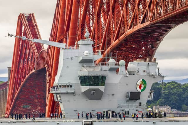 The HMS Queen Elizabeth passes under the Forth Bridge as she heads back to sea following lengthy time at Rosyth for repairs and upgrades due to mechanical fault