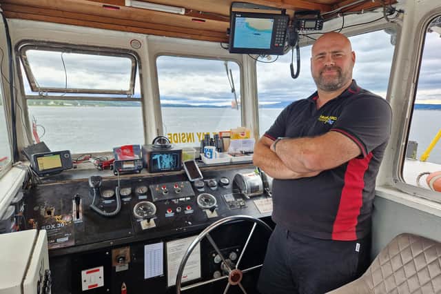 Ferry operator Dougie Robertson at the wheel of the Cromarty-Nigg ferry.